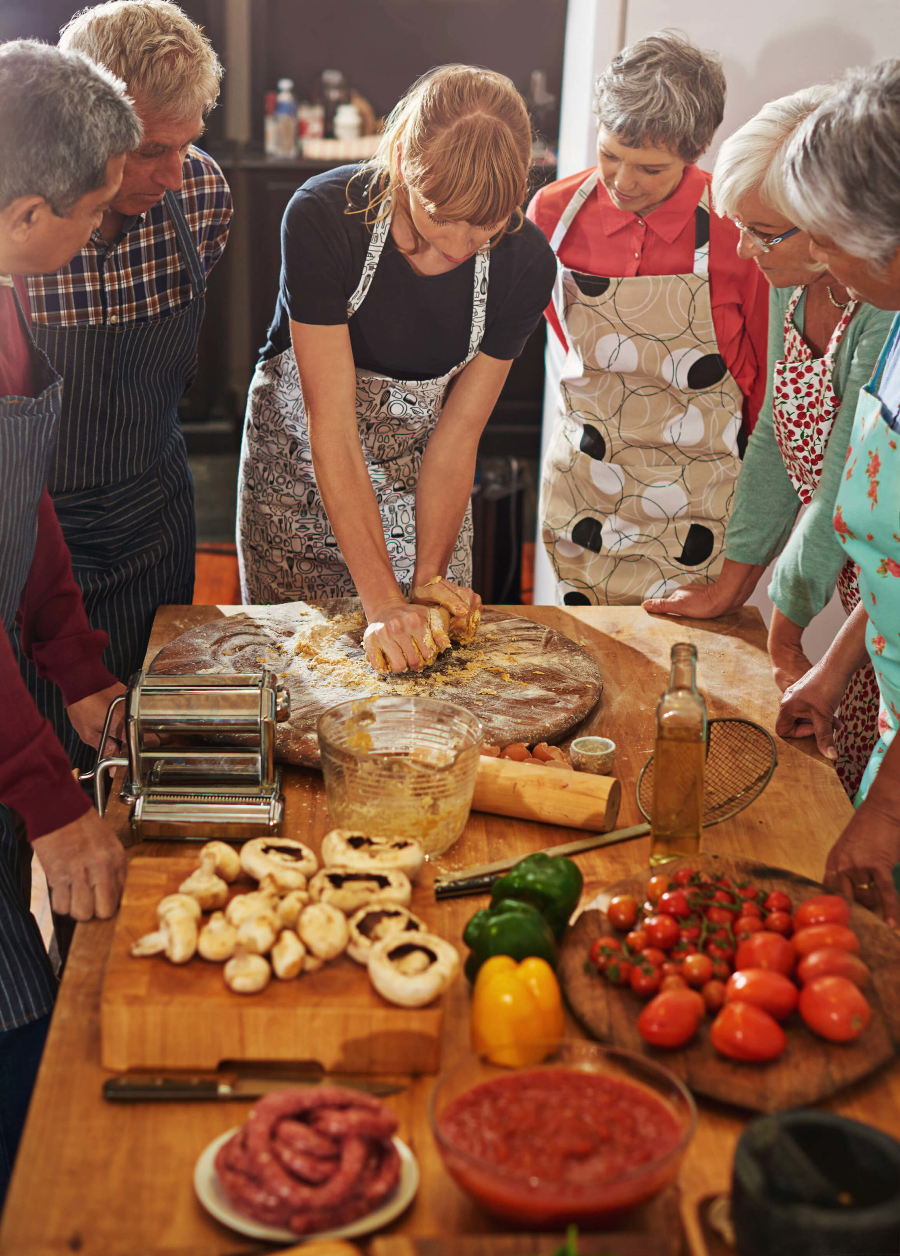 Residents learning to cook healthy meals with an instructor in a spacious kitchen.