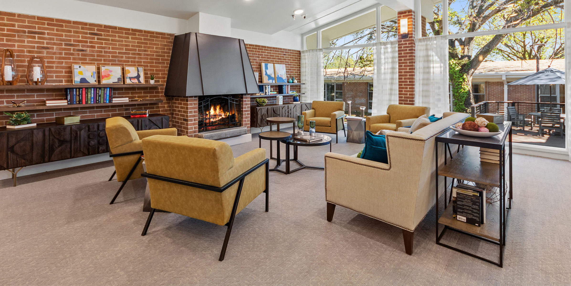 Cozy living room with sofa, armchairs, and fireplace featuring decorated mantel with vases and flowers.