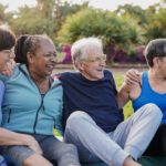 Senior friends having fun together at park after yoga exercise class